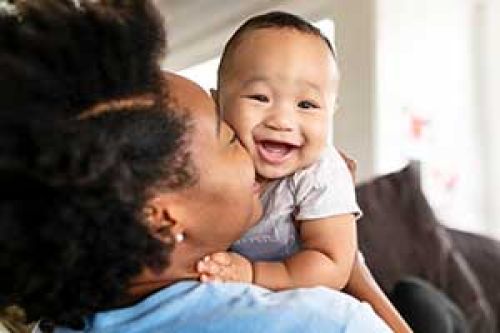 women kissing infant