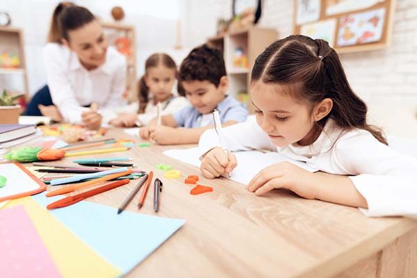 preschoolers writing in notebook