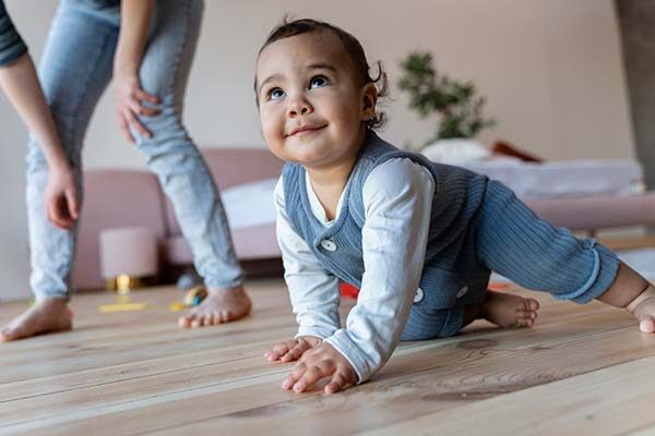 baby smiling while crawling on the floor